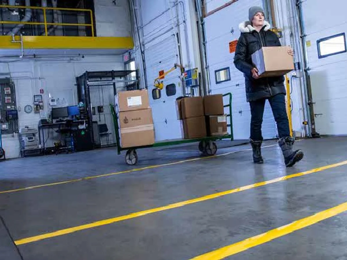 Marcaje de suelo con líneas amarillas delimitando pasillos de seguridad en almacén industrial